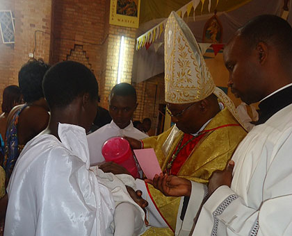 Bishop Phillipe Rukamba baptises a child during the celebrations of Chrismas at Butare Catholic diocese. The New Times / JP. Bucyensenge