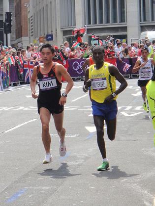 Rwandau2019s Jean Pierre Mvuyekure running alongside  Kwang-Hyok Kim  of North Korea during London 2012 Men's Marathon .