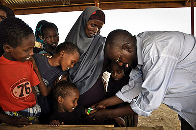 A child has the circumference of his upper arm measured with a MUAC band by MSF health staff, at a health post in Dagahaley refugee camp, Dadaab, Kenya. Net photo.