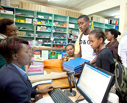 David Kanamugire (L) a 17-year old senior six student  from La Colombiu00e8re together with his sister Naome Ngabire an 11-year old p6 pupil buying scholarstic materials at Caritas bookshop yesterday. The New Times / T.Kisambira.