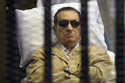 Egyptu2019s ex-President Hosni Mubarak lays on a gurney inside a barred cage in the police academy courthouse in Cairo, Egypt.