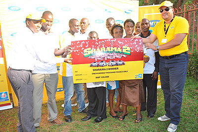 MTNu2019s Sponsorship and Promotional Coordinator Alain Numa hands over a dummy cheque to one of the winners. The New Times/J. Mbanda.