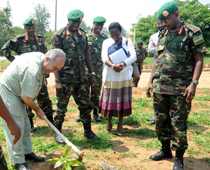 AU Commissioner for Peace and Security Amb. Ramtane Lamamra plants a tree at the Rwanda Military Academy in Gako as Chief of Staff (Land Forces) Maj. Gen. Frank Mushyo Kamanzi  (R)and other senior officers look on yesterday. The New Times/John Mbanda.