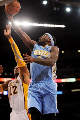 Ty Lawson of the Denver Nuggets drives to the basket against Dwight Howard. Net photo.