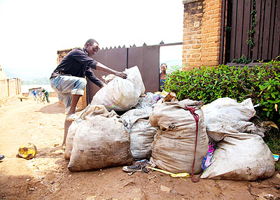 A boy dumps heaps of garbage near a street in Kigali. The New Times/  Timothy Kisambira