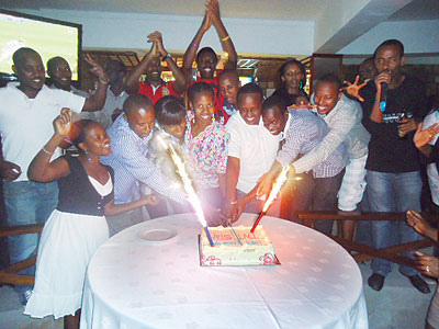 The New Times staff cut the cake at the new year party. The NewTimes / Thomas Kagera.