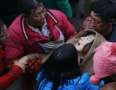 A relative of a victim is comforted at the spot of landslide in Zhenxiong mountain of Zhaotong City, southwest China's Yunnan Province, Jan. 13, 2013. Forty-six people died and 2 others injured in a landslide which hit the Zhaojiagou area of Gaopo Village around 8:20 a.m. Friday. Xinhua/Wang Shen
