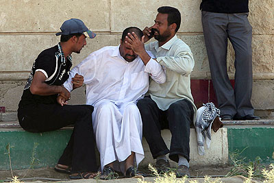 A man is helped after gunmen killed 22 Shiite Muslim pilgrims in Iraq.  Net photo.