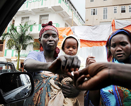 Beggars receive coins from a motorist on the street in Kigali City. Authorities are looking for ways to resettle them. The New Times/ J. Mbanda