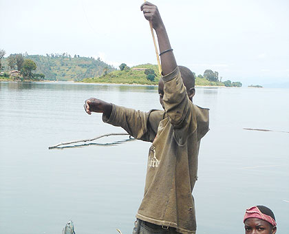 A lad fishing on Lake Kivu recently displays his catch. The New Times/ File