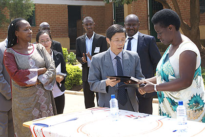 Mutesi receives transfer documents including a cheque from Amb. Shu Zhan on Tuesday. The New Times/  Courtesy. 