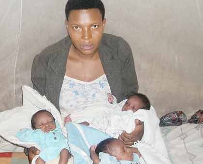 Nyirasafari holds her triplets at her home in Ikaze village at the weekend. The New Times/  Fiacre Igihozo