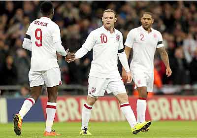 England players rush to congratulate Wayne Rooney after he put the hosts a goal up after 26 minutes. England beat Brazil 2-1. Net photo.