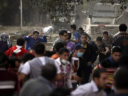 Egyptian anti-government protesters sit waving their national flag outside the presidential palace in Cairo during a demonstration against the Muslim Brotherhood. Net photo.