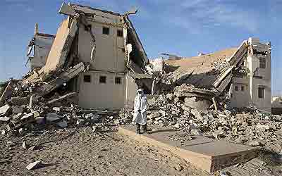 Farag Mohamed Arbi stands outside the building where he worked as a chef for Al Qaeda fighters. Net photo.