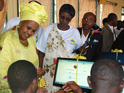 Zulphat Mukarubega, board member of the MTN Foundation, talks with students trying out the new computers. 