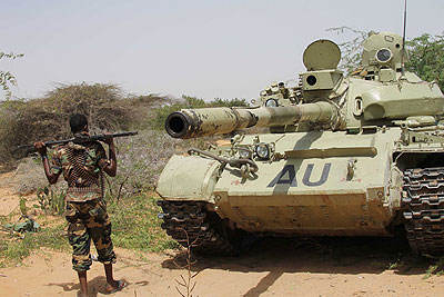 A Somali Transitional Federal Government soldier stands beside an AMISOM tank in the front lines of the battle against al-Shabaab. The Somali government has asked the UN to lift the ar....
