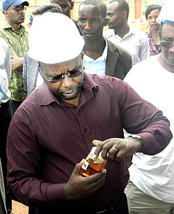 PM Habumuryemi looks at a bottle of cooking oil at the plant yesterday. The New Times/ S. Rwembeho.