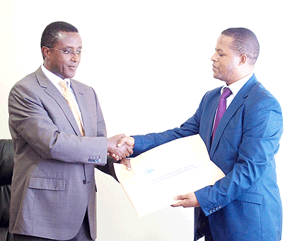 Education Minister Vincent Biruta (L) receives a parcel containing TVET examinations results from WDA Director-General Jerome Gasana, yesterday. The New Times/  Timothy Kisambira.