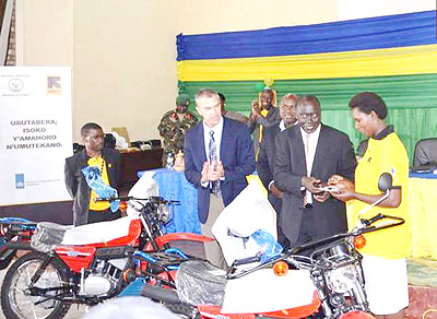Karugarama (2ndR) hands over motorcycles keys to MAJ staff as Crothers looks on. The New Times/ S. Rwembeho