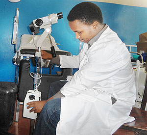 Dr Ntirushwa tries out the cancer magnifying device. The New Times/ Sam K. Nkurunziza.