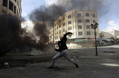 A Palestinian protester throws a stone during clashes with Israeli soldiers and border policemen in the West Bank city of Hebron on Feb. 24, 2013. The death in an Israeli jail of a Pal....