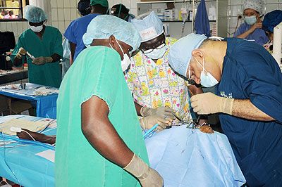 Doctors operate on a clef lip patient at CHUK yesterday. INSET, a baby with cleft lips await surgery at the hospital, while below, one of the babies after successful operation. The New....