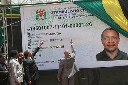 President Jakaya Kikwete, wearing a black suit, inspects a billboard-sized copy of his identity card in February 2013.  Net photo.