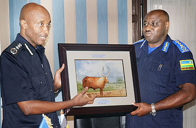 Kayihura (L) hands a gift to his host, Gasana, yesterday.  The New Times/ John Mbanda.