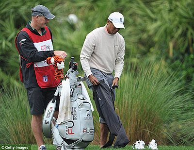 Tiger Woods hit a 200-yard shot out of a water hazard after finding his ball. Net photo.
