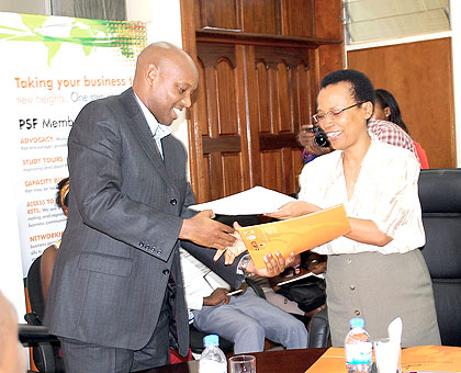 Namara (L) and Mukankomeje exchange the MoU.  The New Times/ T. Kisambira.