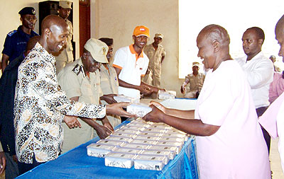 Harelimana (L) serves packed food to Huye Prison inmates in July last year. The New Times/ File.