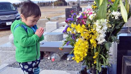 A little boy prays for his relatives killed in the 2011 disaster. Net photo.