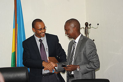 Karitanyi (left) shakes hands with Muyange after receiving tools of  office on Monday. The New Times/ Johm Mbanda