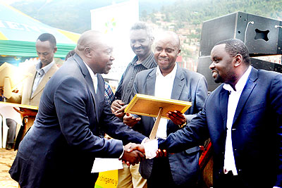 Nzeyimana (R) congratulates one of the taxpayers rewarded yesterday.  The New Times/ Courtesy.
