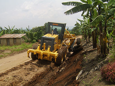 Grader opens a road in rural Uganda. AfDB is funding a road improvement project in the country. Net photo.