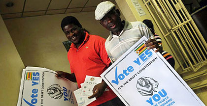 Men hold up posters calling on Zimbabweans to vote yes in the constitutional referendum. Net photo.