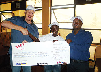 A sports betting winner receives a dummy cheque from New Africa Gaming officials last week. The New Times/J. Mbanda