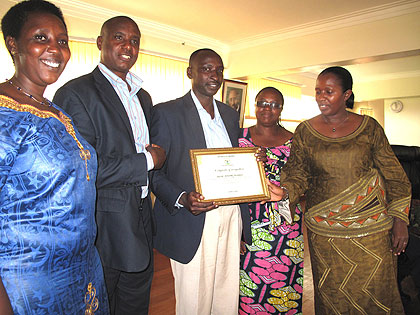 Governor Uwamariya (R) awards Byaruhanga certificate of recognition. The New Times/ Stephen Rwembeho.