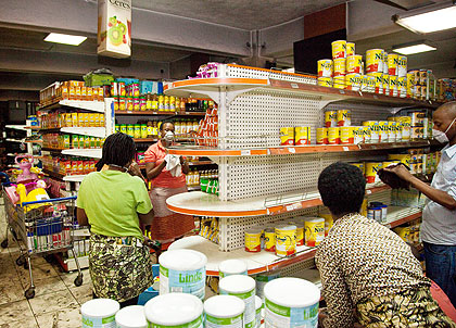 Simba Supermarket staff re-organise stalls after the fire outbreak yesterday. The New Times/ Timothy Kisambira. 