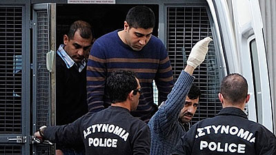 Riot police lead Hossam Taleb Yaacoub, a 24-year-old Swedish-Lebanese citizen, centre top, to the court in the southern port city of Limassol Cyprus, March 7, 2013. The trial of a self....