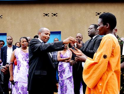 Rusagara hands over a house key to Jacqueline Kayitesi, a beneficiary.  The New Times/  Laurent Kamana.
