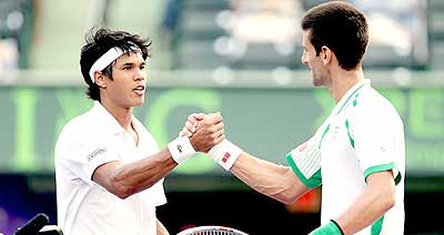 Novak Djokovic (right) shakes hands with Somdev Dewarman. Net photo.