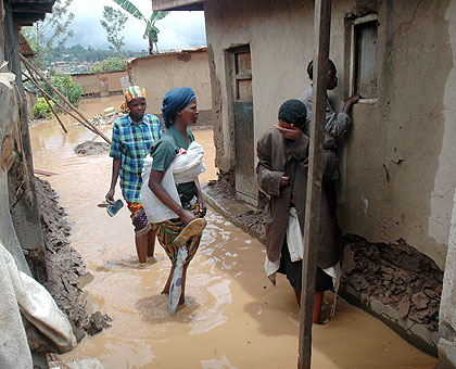 A woman cries after her house was hit by floods. City authorities say about 10,000 families live in houses located on steep hillsides and marshland.  The New Times/John Mbanda. 