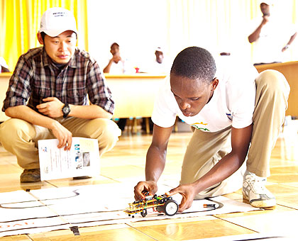 Joel Manishimwe (R) prepares his robot during the innovation contest yesterday. The New Times/  Timothy Kisambira.