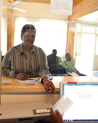 A client at a microfinance bank in Remera, Kigali. The sector says tax laws are stiffling its growth.  The New Times / Timothy Kisambira.