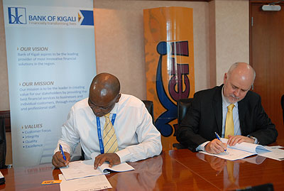 Naibo (left) and Coetzee sign the deal for e-commerce gateway at Bank of  Kigali headquarters yesterday.  The New Times/Courtesy photo..