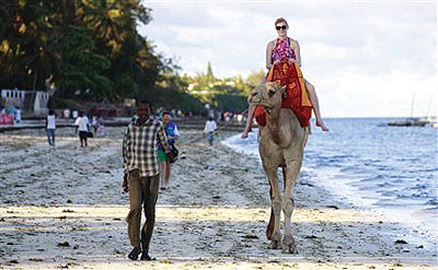 A tourist rides on a camelu2019s back at the Jomo Kenyatta public beach in Kenyau2019s coastal city of Mombasa. Kenyau2019s tourism industry may be a swift winner from the election of Uhuru ....