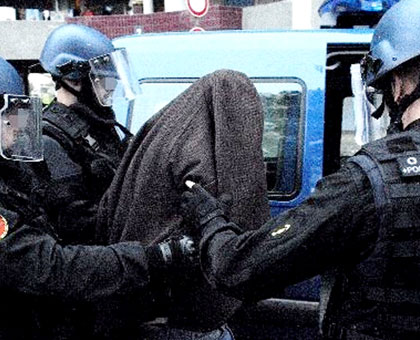 Barahira (hooded) is led into a police van in Toulouse. Net photo.