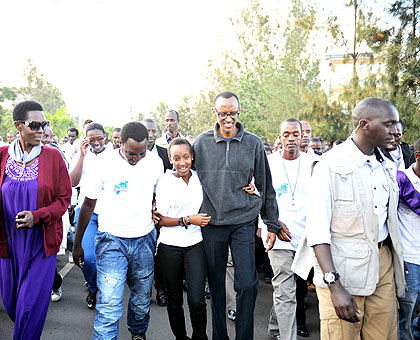President Kagame (in dark-blue blazer) holds a youth during the Walk To Remember in Kigali yesterday.   The New Times/ Village Urugwiro.